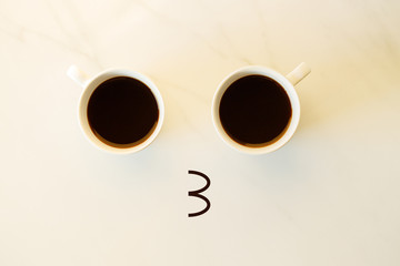 Two cups of coffees arranged as human face with line showing emotion. kiss