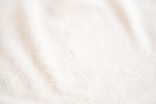 Soft cozy plaid made of white fabric with a pile lies in beautiful folds
