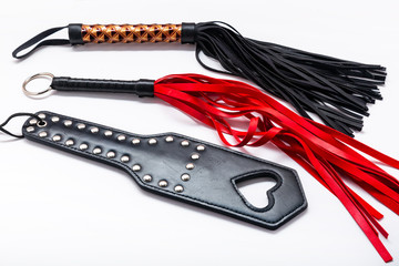 Whip on white background. Accessories for adult sexual games. Toys for BDSM, spanking devices....