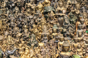 Large group of various bronze figurines of Hindu deities and Buddhas in a souvenir shop in Kathmandu city, Nepal. Street retail theme.