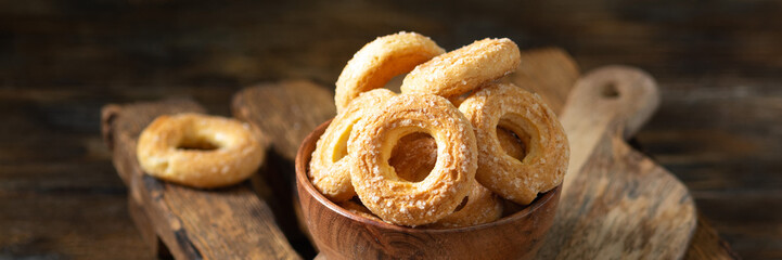 Sprinkle the puff pastry with sugar in a wooden bowl on a wooden table. Sprinkle the cookies with sugar. Sweet pastries. Banner