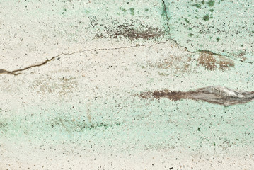 Texture of an old concrete wall with cracks. Green wall with scratches.