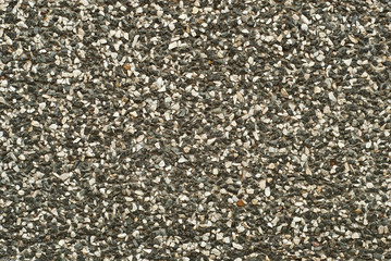 The texture of the wall is made of small yellow, black and white stones.