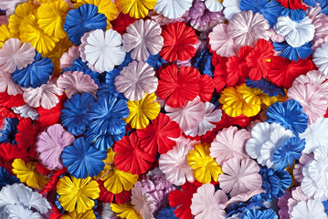 Fototapeta na wymiar Preparations for artificial flowers. Texture of plastic flower petals. Many colored flowers close up.