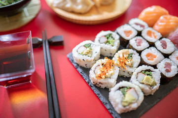 Set of sushi.Sushi rolls set with tuna and salmon fish, soya sauce ,wakame salad isolated on red background.