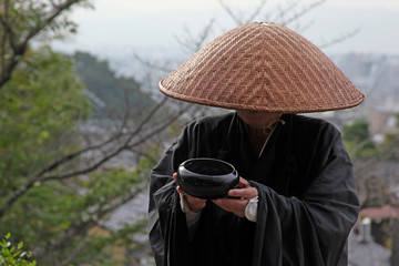 Man asks for alms, hiding his face