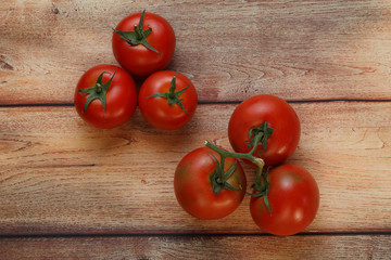 Six branch tomatoes on wooden table viewed from above