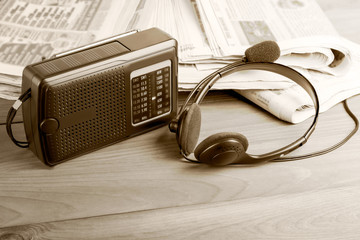 Radio, headphones with a microphone and newspapers on the office desk, media latest news concept.