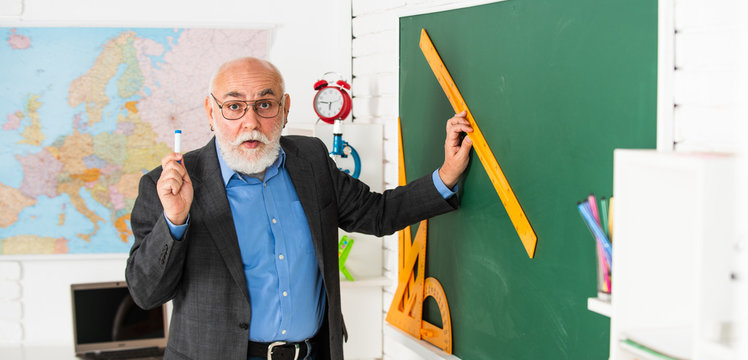 good idea. high school modern education. senior man teacher use ruler while drawing. tutor man in glasses draw with ruler on blackboard. back to school. what angle you look. geometric shapes