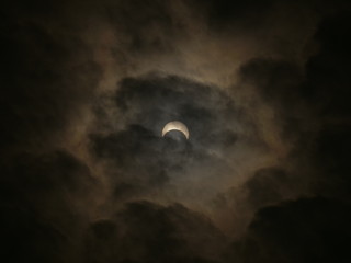 Mysterious astrology nature phenomena -- sun moon eclipse daytime on the cloudy sky