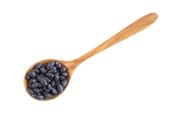Closeup black beans seeds in wood spoon on white background, healthy food concept
