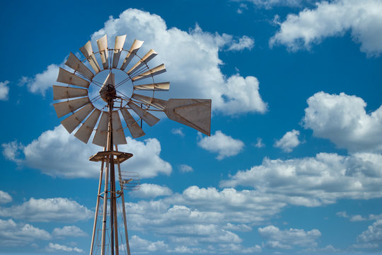 Image of old metal Wind mill against a blue sky