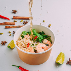 Asian food, with seafood and sauce, on a colored background