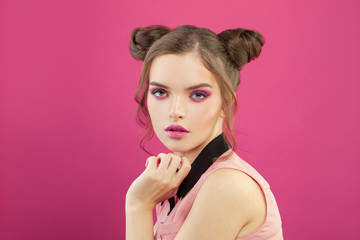 Attractive woman with fashion makeup on bright pink background