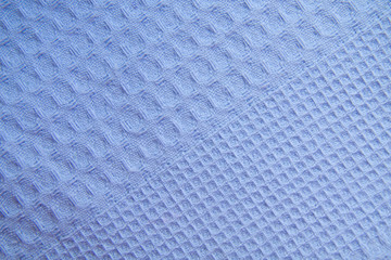 Blue uniform background with the texture of a waffle kitchen towel. Concept cooking blog, cooking at home.