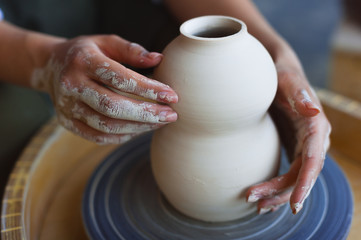 Hands working on pottery wheel