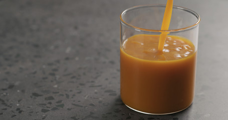 sea buckthorn juice pour into beaker glass on concrete surface