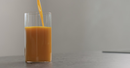 sea buckthorn juice pour into beaker glass on concrete surface