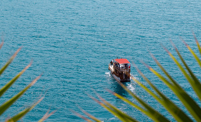 Obraz premium A yacht with people the coast of the Mediterranean Sea in Antalya, turkey.