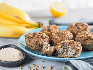 Close-up view of healthy gluten-free homemmade banana muffins with buckwheat flour. Vegan muffins with poppy seeds on blue plate over gray wooden table. Copy space