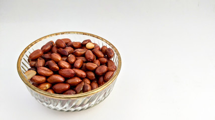 Roasted peanuts in glass bowl, Isolated on white background.

