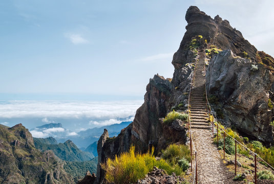 "Stairs to heaven" - Breathtaking view at famous mountain footpath from Pico do Arieiro to Pico Ruivo on the Portuguese Madeira island. Trekking Around the world traveling with kids concept image.