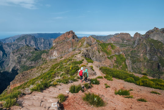 Mother with teenager son trekking the famous mountain footpath from Pico do Arieiro to Pico Ruivo on the Portuguese Madeira island. Around the world traveling with kids concept image.