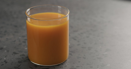 sea buckthorn juice in beaker glass with water on concrete surface