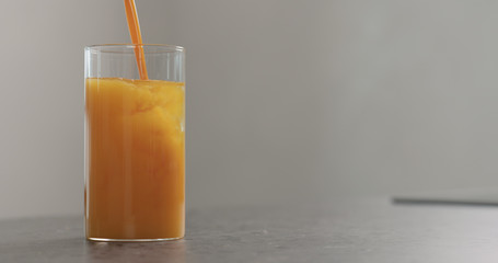 sea buckthorn juice pour into beaker glass with water on concrete surface