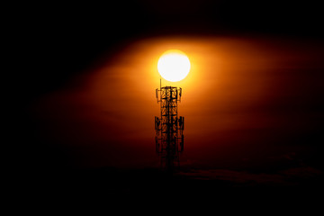 Big sunset on communication towel on big red sun sky and cloud background, beautiful landscape on technology on nature sky, high view on top telecommunication for broadcast satellite signal industry