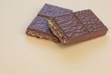 Pieces of a chocolate bar on a light background. Chocolate waffles.