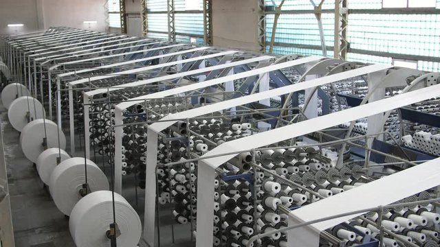 A lot of lines of coils with white plastic ropes for plastic sacks at agro factory