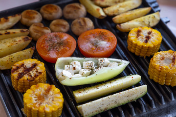 Electric grill with spicy potatoes, mushrooms and vegetables