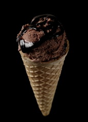 Ice cream in cone with chocolate topping isolated on black background, clipping path