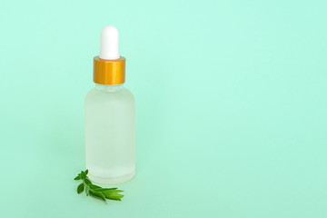 Glass cosmetik bottle with oil. container for a product for women with small white flowers on a turquoise background. Cosmetic jar. Place for text
