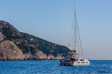 Sailing yacht in open sea on beautiful sunset sky background. yacht on beautiful beach Porto Katsiki Lefkada