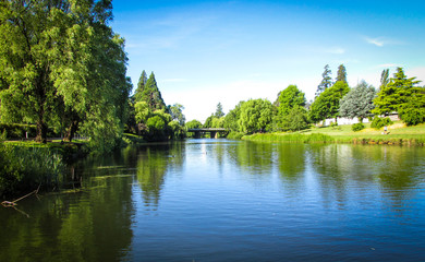 Obraz premium View of Meander River with The Meander River Bridge in the distance. Taken in Deloraine, a tourist destination town because of its proximity to the surrounding Tasmanian natural attractions 