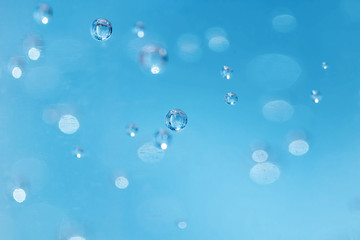Bubbles are blurred from in the alcohol gel bottle and the blue background.