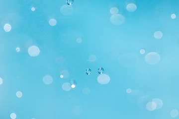 Bubbles are blurred from in the alcohol gel bottle and the blue background.