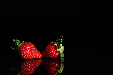 Strawberries on a black background with reflection