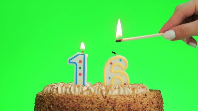 Lighting a number sixteen birthday candle on a delicious cake, green screen 16