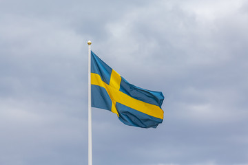 Swedish flag as proudly fluttering in the wind against a blue sky