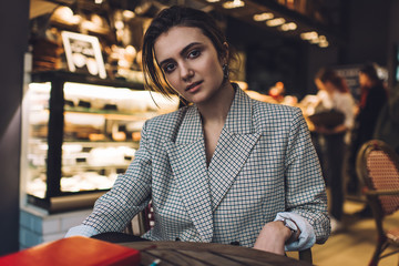 Confident trendy woman sitting in restaurant