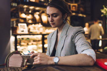 Young woman using smartphone in cafeteria