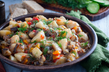 Vegetable stew with potatoes and eggplant in a clay bowl, vegetarian recipe, selective focus