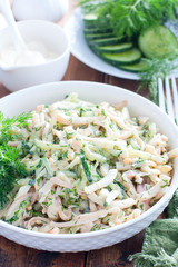 Salad with squid, eggs and fresh cucumbers, selective focus
