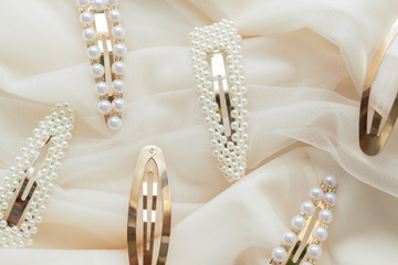 pattern of hair clips with pearls on beige tulle background