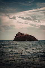 Rocky Atlantic shoreline under dramatic cloudscape. Sunrise on Cape Verde. View from the sea