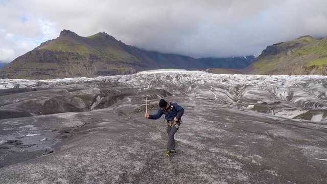 A young man walking on the Svinafellsjokull glacier one summer morning. Iceland