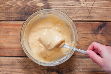 Step-by-step preparation of fried pollock fillet in batter, step 4 - dipping pollock in batter, top view, selective focus